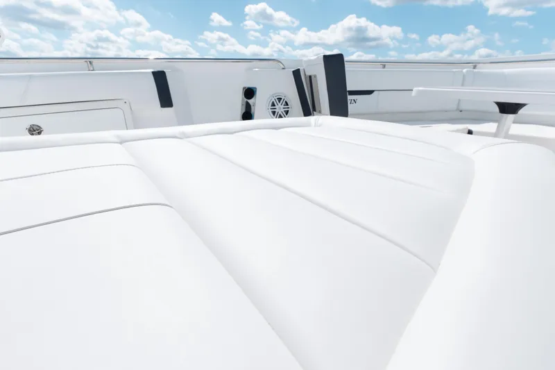Slide: The Image of 2021 Blackfin 332 CC boat interior with white cushioned seating under a blue sky. - 84