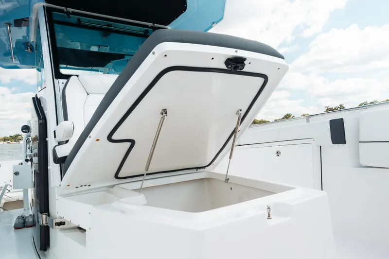 Slide: The Image of 2021 Blackfin 332 CC boat with open storage compartment, showcasing sleek design. - 89