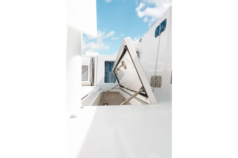 Slide: The Image of Open storage compartment on 2021 Blackfin 332 CC boat under a clear blue sky. - 93