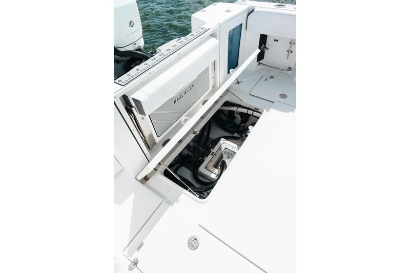 Slide: The Image of 2021 Blackfin 332 CC boat with open storage compartment and visible engine components. - 94