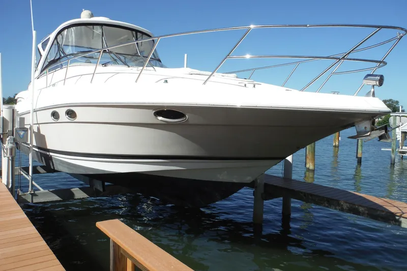Slide: The Image of 2008 Regal Commodore 3760 IO boat docked on a lift, clear blue sky background. - 2