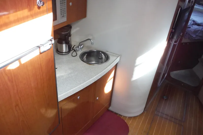 Slide: The Image of 2008 Regal Commodore 3760 IO yacht interior with kitchenette, sink, and wooden cabinetry. - 29