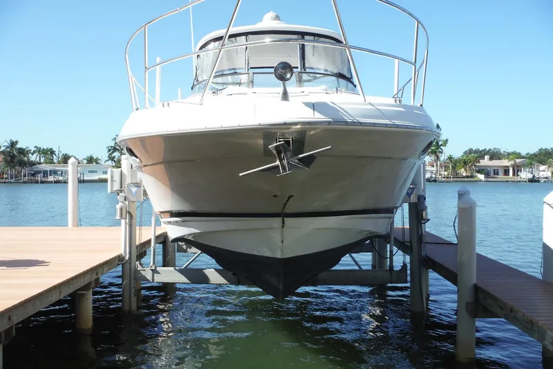 Slide: The Image of 2008 Regal Commodore 3760 IO boat docked on a lift by the water. - 3