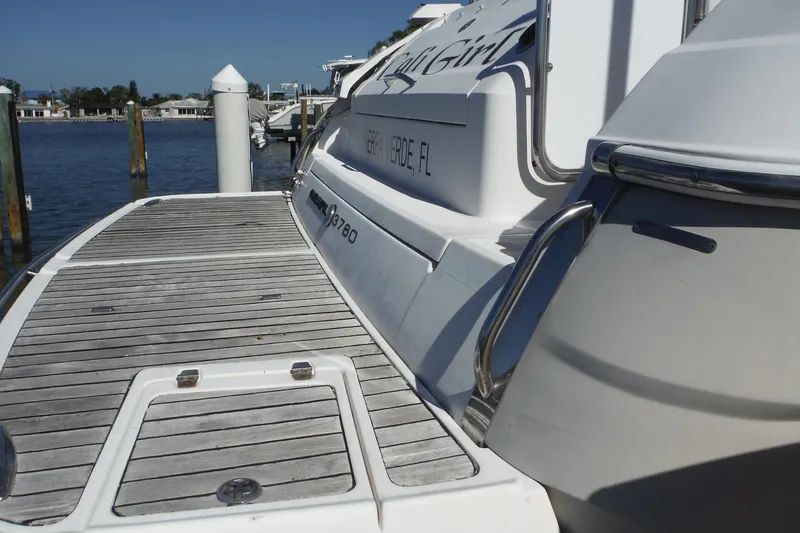 Slide: The Image of 2008 Regal Commodore 3760 IO yacht docked at a marina, featuring a wooden deck. - 44