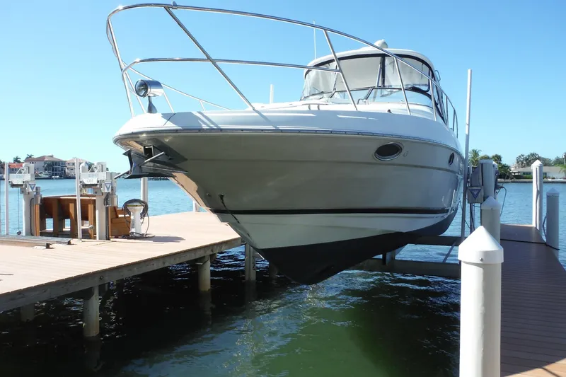 Slide: The Image of 2008 Regal Commodore 3760 IO yacht docked on a lift by the water. - 5