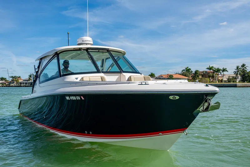 Slide: The Image of 2017 Pursuit DC 295 Dual Console boat cruising on clear waters, with a scenic coastal backdrop. - 1