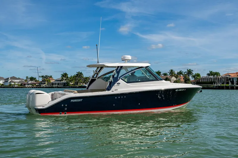 Slide: The Image of 2017 Pursuit DC 295 Dual Console boat cruising on a sunny day near waterfront homes. - 10