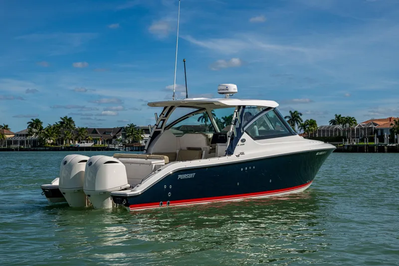 Slide: The Image of 2017 Pursuit DC 295 Dual Console boat on calm water, clear sky background. - 11