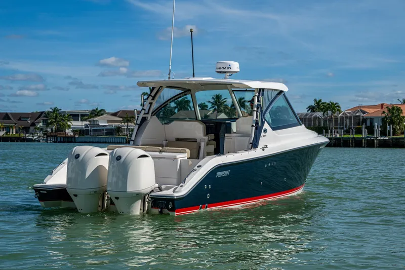 Slide: The Image of 2017 Pursuit DC 295 Dual Console boat on water, featuring twin engines. - 12