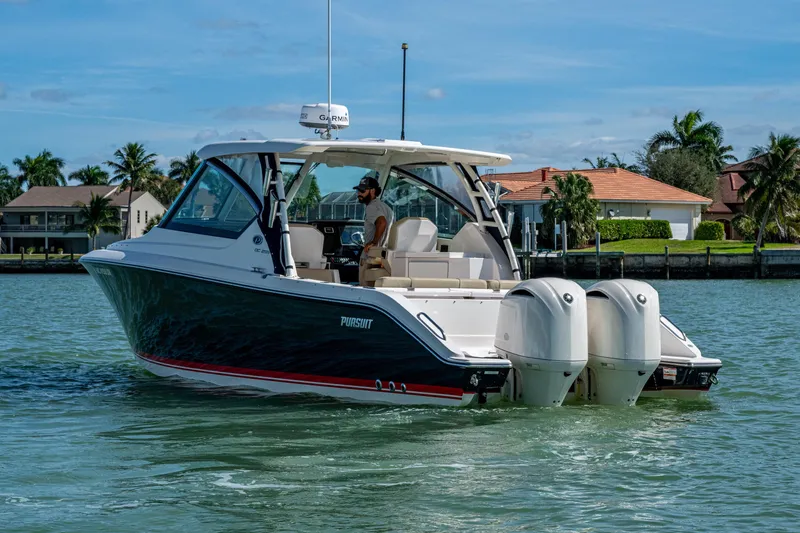 Slide: The Image of 2017 Pursuit DC 295 Dual Console boat cruising on a sunny day near waterfront homes. - 14