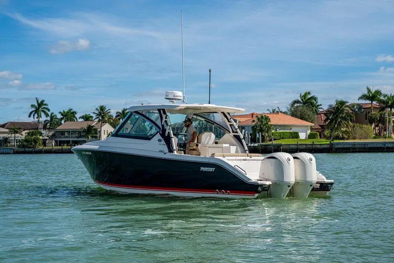 Slide: The Image of 2017 Pursuit DC 295 Dual Console boat cruising on a sunny day near waterfront homes. - 15