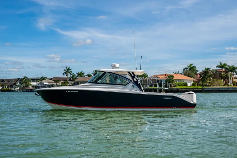 Slide: The Image of 2017 Pursuit DC 295 Dual Console boat cruising on a sunny day near waterfront homes. - 18