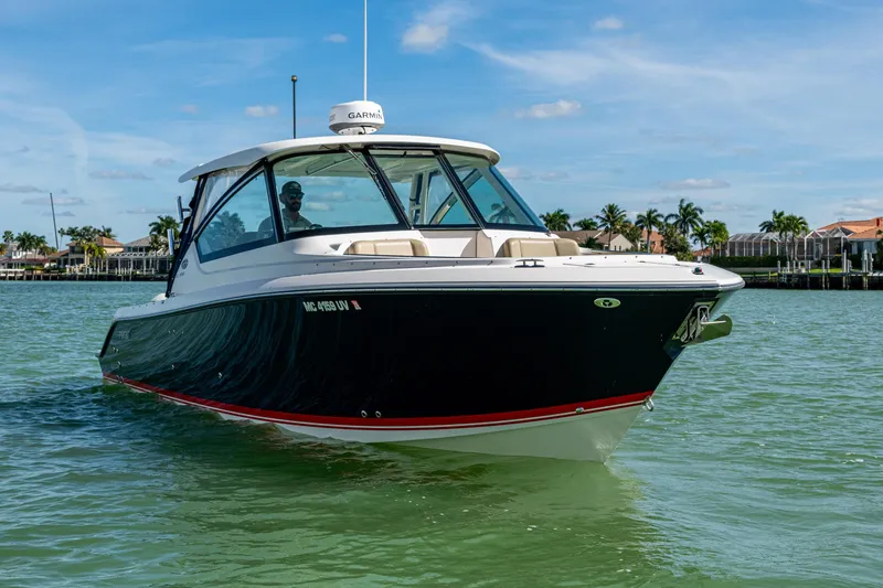 Slide: The Image of 2017 Pursuit DC 295 Dual Console boat cruising on clear waters under a blue sky. - 2