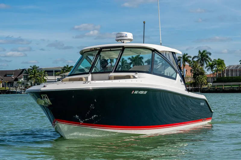 Slide: The Image of 2017 Pursuit DC 295 Dual Console boat cruising on a sunny day near palm trees. - 21