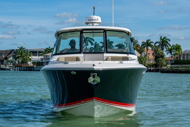 Slide: The Image of 2017 Pursuit DC 295 Dual Console boat on water, with palm trees in the background. - 22