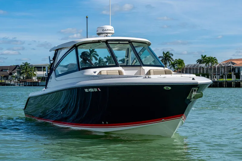 Slide: The Image of 2017 Pursuit DC 295 Dual Console boat cruising on a sunny day near waterfront homes. - 23