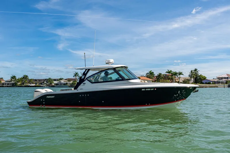 Slide: The Image of 2017 Pursuit DC 295 Dual Console boat on calm water, clear sky background. - 25