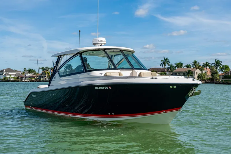 Slide: The Image of 2017 Pursuit DC 295 Dual Console boat on calm water, clear sky background. - 3