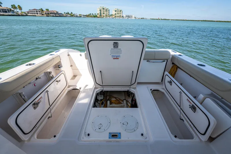 Slide: The Image of 2017 Pursuit DC 295 Dual Console boat with open storage compartments on calm water. - 30