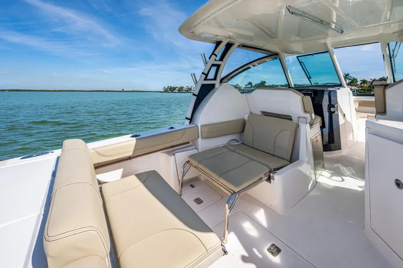 Slide: The Image of 2017 Pursuit DC 295 Dual Console boat interior with beige seating and open water view. - 34