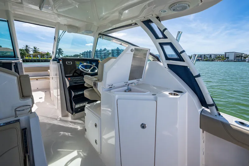Slide: The Image of 2017 Pursuit DC 295 Dual Console boat interior with helm, seating, and water view. - 37
