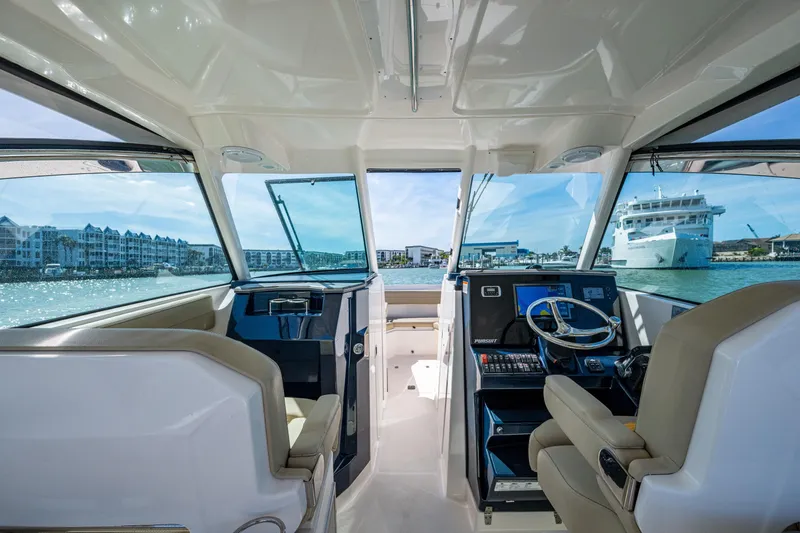 Slide: The Image of Interior view of 2017 Pursuit DC 295 Dual Console boat with waterfront scenery. - 38
