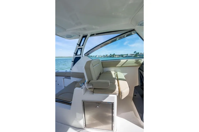 Slide: The Image of 2017 Pursuit DC 295 Dual Console interior with beige seating and ocean view. - 40