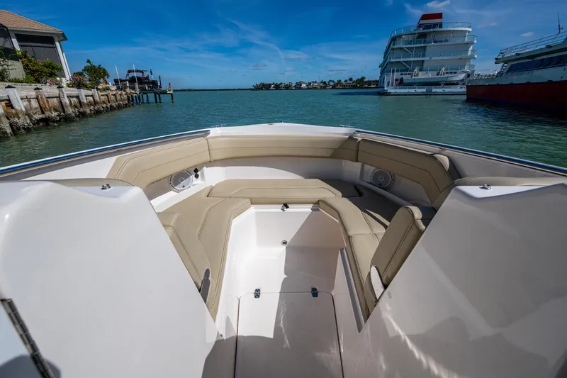 Slide: The Image of 2017 Pursuit DC 295 Dual Console boat interior with beige seating, docked near waterfront. - 47