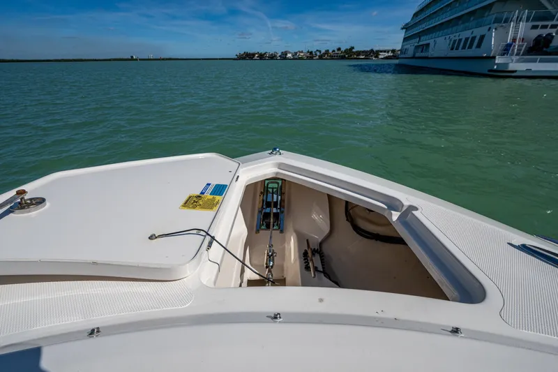 Slide: The Image of 2017 Pursuit DC 295 Dual Console boat on calm water, open storage compartment visible. - 49