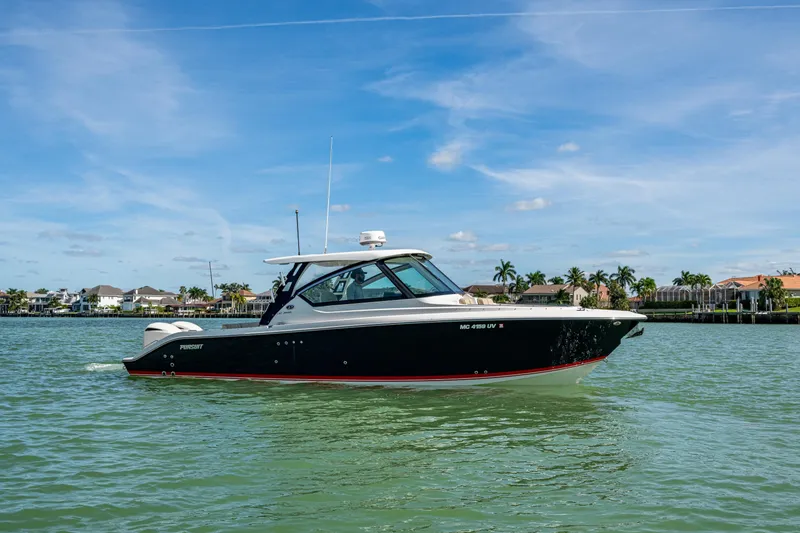 Slide: The Image of 2017 Pursuit DC 295 Dual Console boat cruising on a sunny day near waterfront homes. - 6