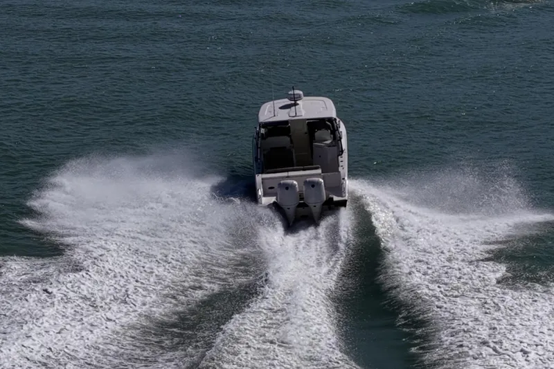 Slide: The Image of 2017 Pursuit DC 295 Dual Console boat cruising on open water, leaving a wake. - 65