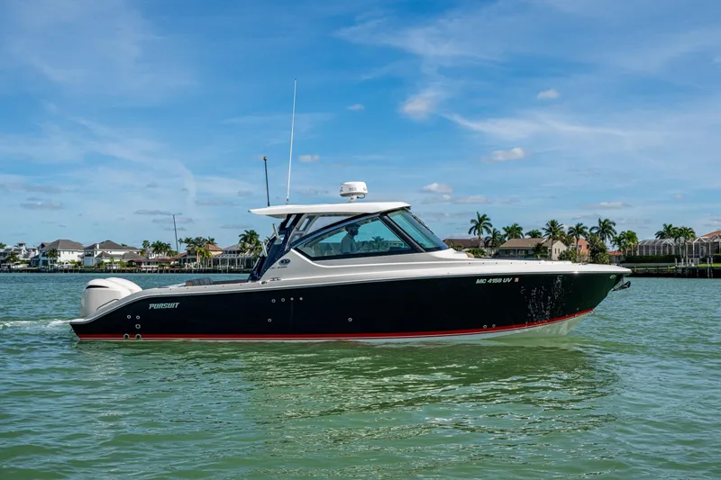 Slide: The Image of 2017 Pursuit DC 295 Dual Console boat cruising on calm waters under a clear blue sky. - 7