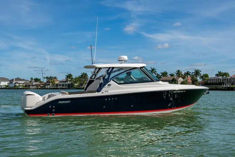 Slide: The Image of 2017 Pursuit DC 295 Dual Console boat on calm water, clear sky background. - 9