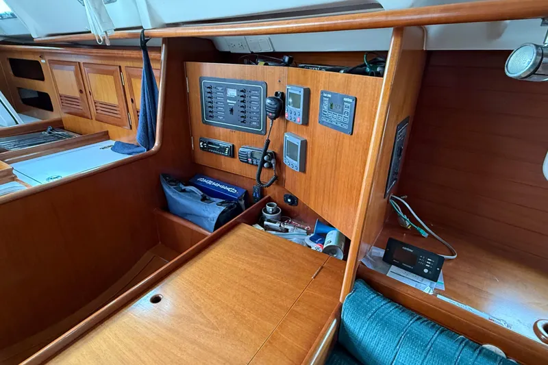 Slide: The Image of Interior of 2000 Beneteau 361 sailboat with navigation equipment and wooden cabinetry. - 11
