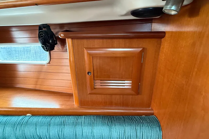 Slide: The Image of Interior of 2000 Beneteau 361 yacht with wooden paneling and small cabinet. - 12