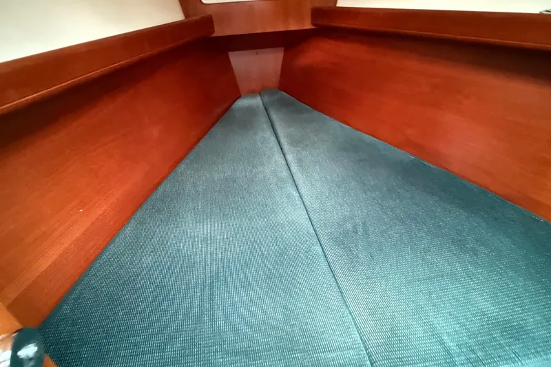 Slide: The Image of Interior cabin of 2000 Beneteau 361 sailboat with wooden finish and blue upholstery. - 16