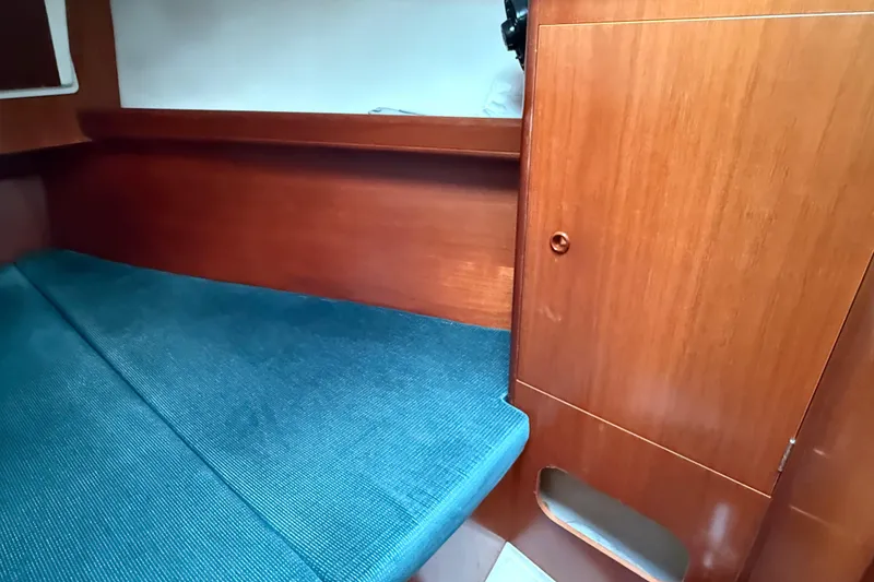 Slide: The Image of Cozy cabin interior of 2000 Beneteau 361 sailboat with wooden finish and blue upholstery. - 17