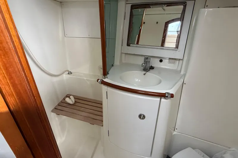 Slide: The Image of Bathroom interior of 2000 Beneteau 361 yacht with sink, mirror, and shower area. - 18