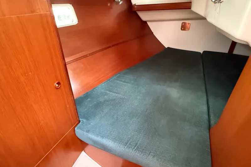 Slide: The Image of Cozy cabin interior of 2000 Beneteau 361 sailboat with wooden finish and cushioned berth. - 19