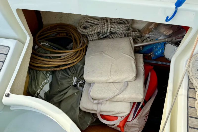 Slide: The Image of Storage compartment of a 2000 Beneteau 361 sailboat with ropes and cushions. - 23