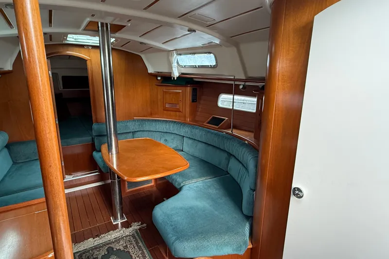 Slide: The Image of Interior of 2000 Beneteau 361 sailboat with wood finish and blue seating. - 6