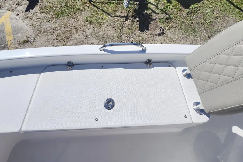 Slide: The Image of 2026 Savannah 210X boat deck with storage compartment and cushioned seat. - 14