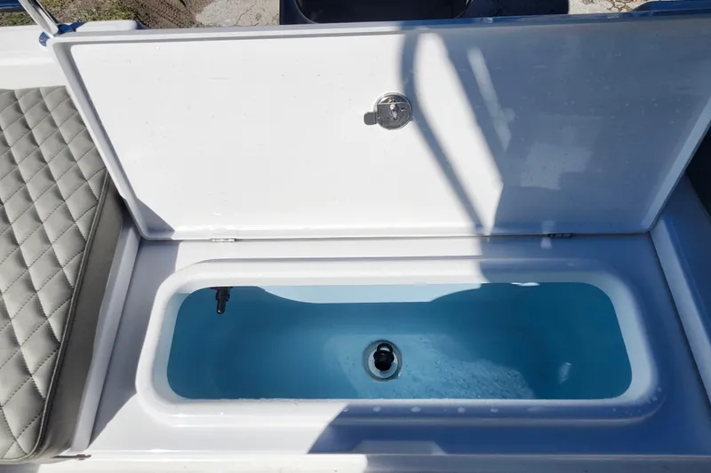 Slide: The Image of Open storage compartment on 2026 Savannah 210X boat with quilted seating. - 26