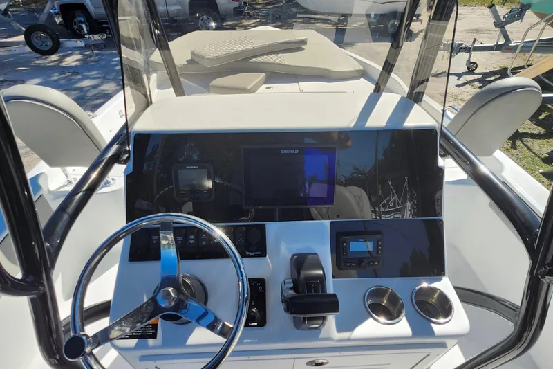 Slide: The Image of 2026 Savannah 210X boat dashboard with steering wheel, controls, and navigation screens. - 32