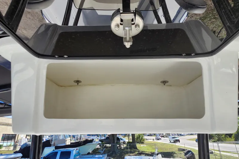 Slide: The Image of Open storage compartment on a 2026 Savannah 210X boat, with visible latch mechanism. - 39