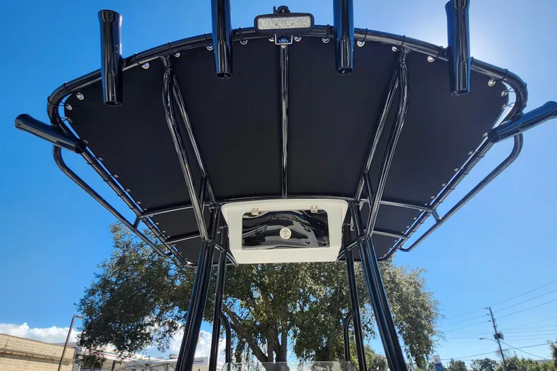 Slide: The Image of 2026 Savannah 210X boat canopy with rod holders under clear blue sky. - 42
