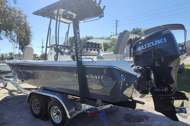 Slide: The Image of 2026 Savannah 210X boat with Suzuki engine on a trailer, parked outdoors. - 5