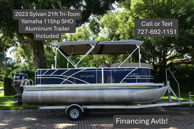 The Image of 2023 Sylvan Mirage Fish 820 Party Fish pontoon boat on trailer, trees in background. - 0