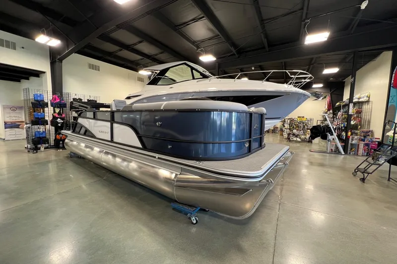 The Image of 2026 Crest Conquest 230 SLSC pontoon boat displayed in a showroom setting. - 1