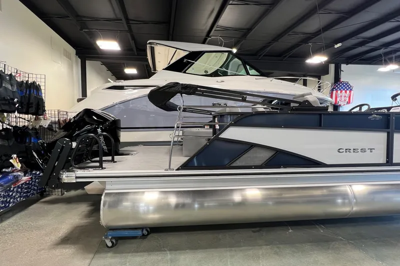 Slide: The Image of 2026 Crest Conquest 230 SLSC pontoon boat displayed indoors with accessories. - 5